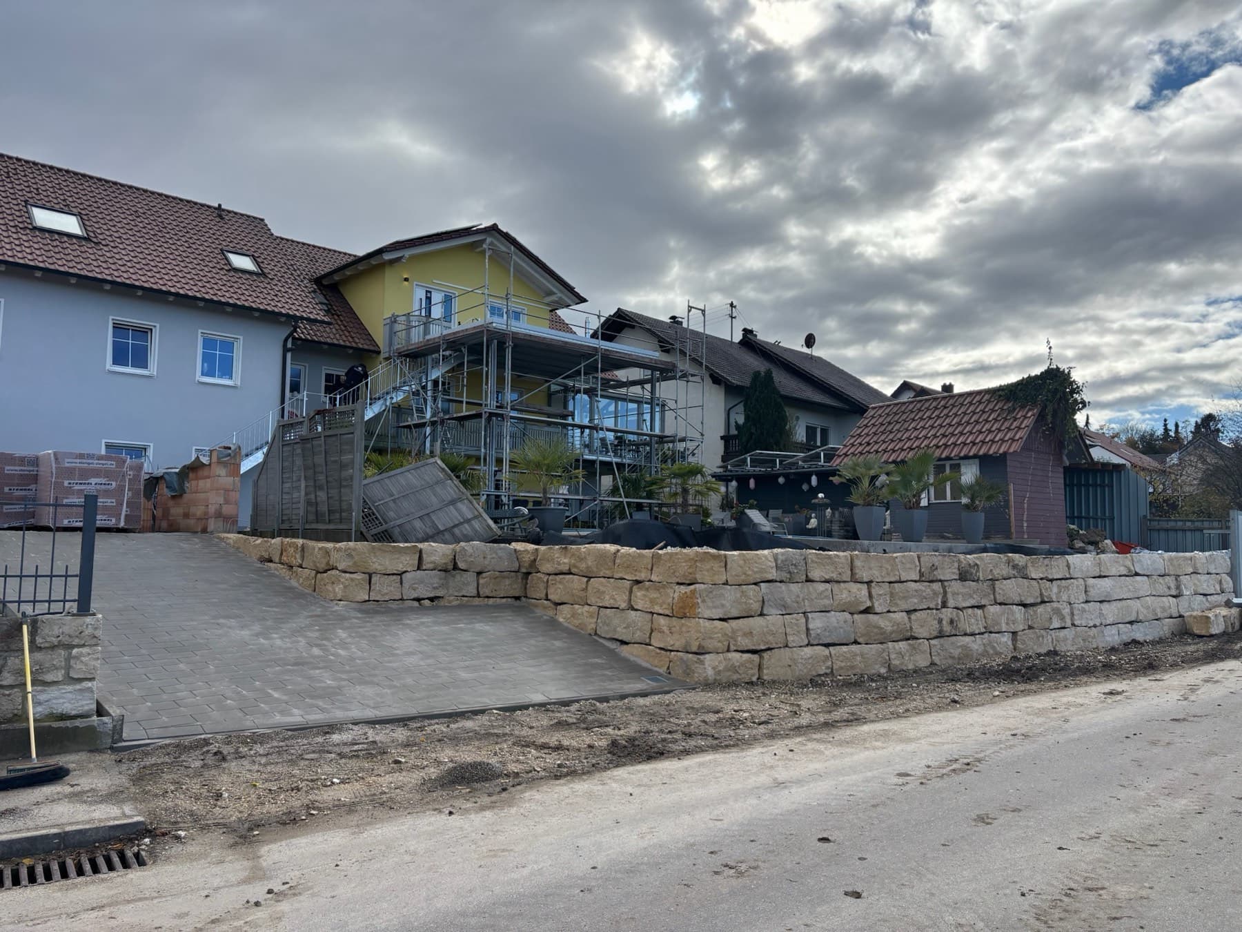 Natursteinmauer mit Betonplatte vor dem Haus