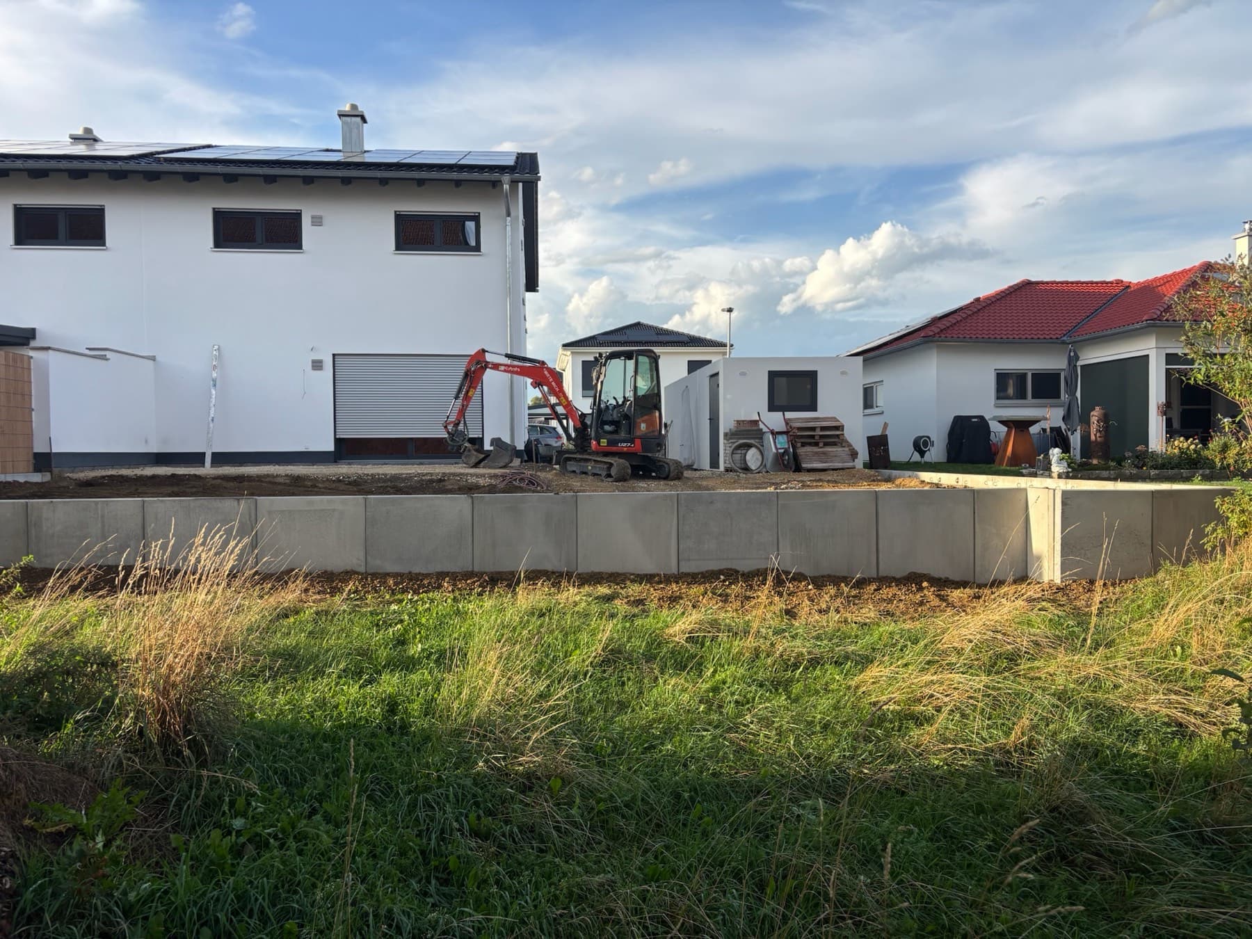 L-Steine, Rasen und Beet vor dem Haus