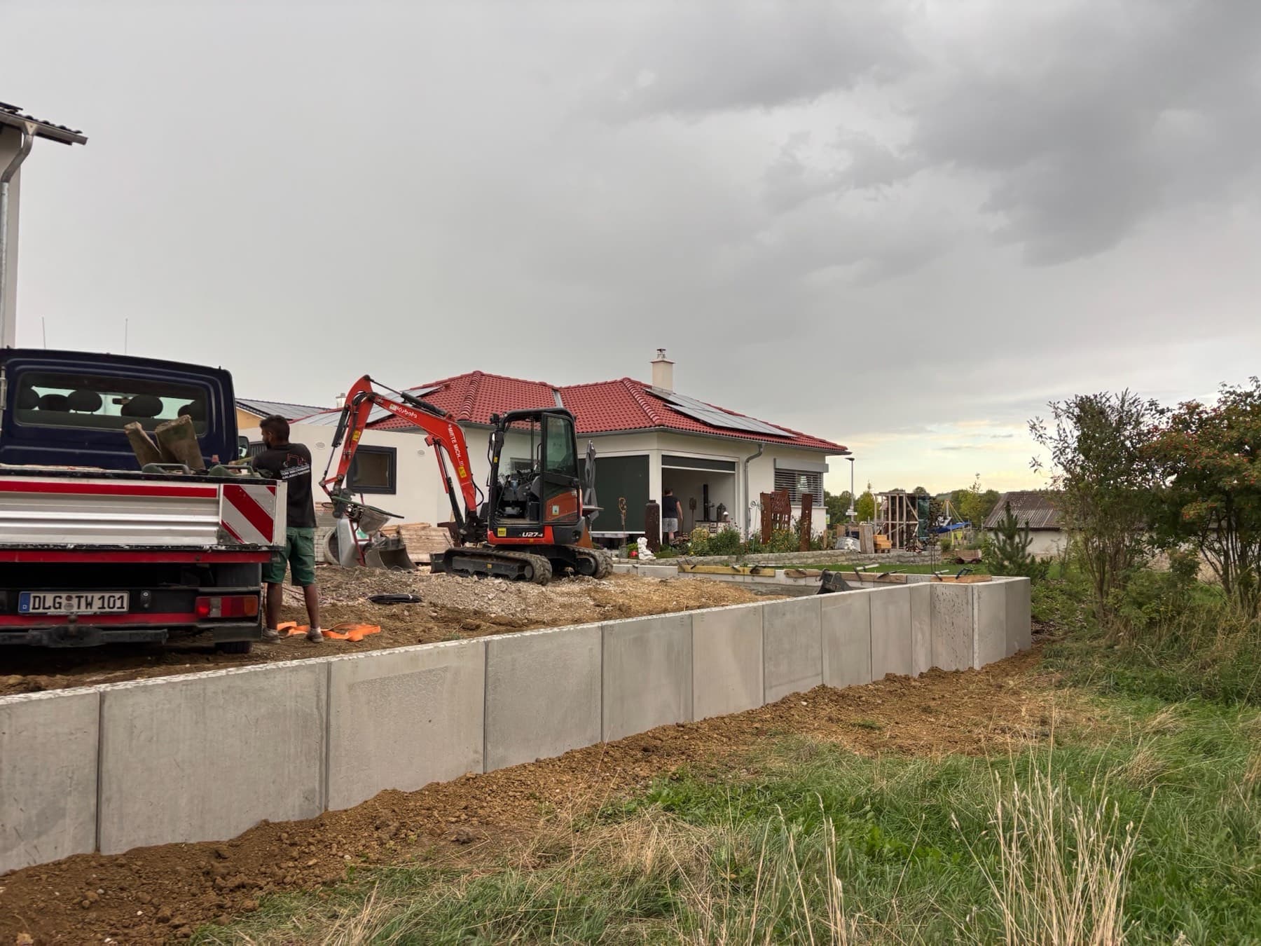 L-Steine werden mit dem Bagger gesetzt